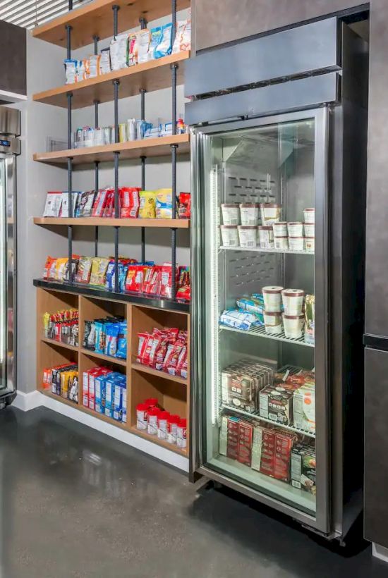 The image shows a small store with shelves and refrigerated displays stocked with various packaged snacks and beverages.